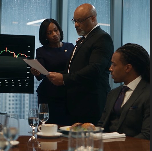 Dr. Boyce Watkins reviewing a financial report in a boardroom